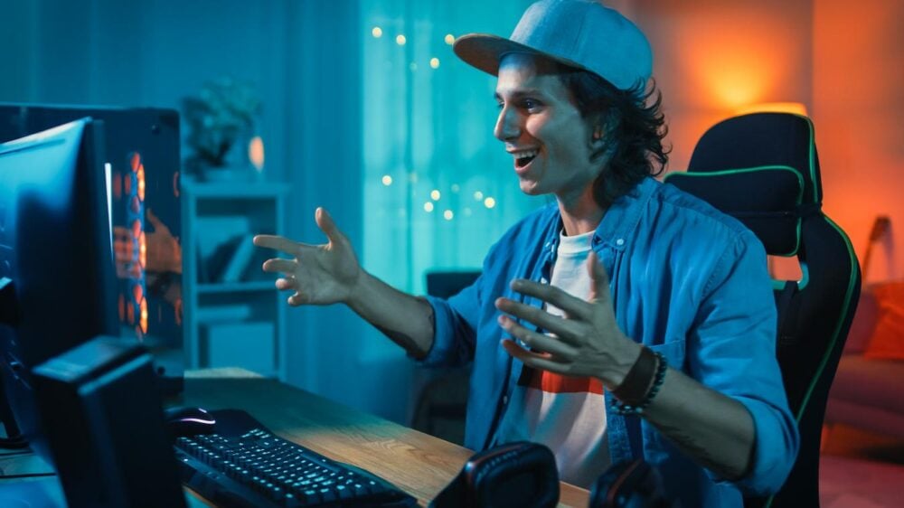 a boy in his bedroom wearing a hat playing video games tuck guys neck women bun worn style wear a hat baseball caps style