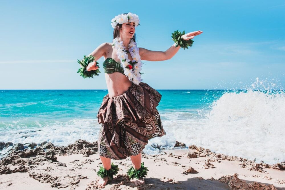 hawaiian woman in traditional hula attire on the beach