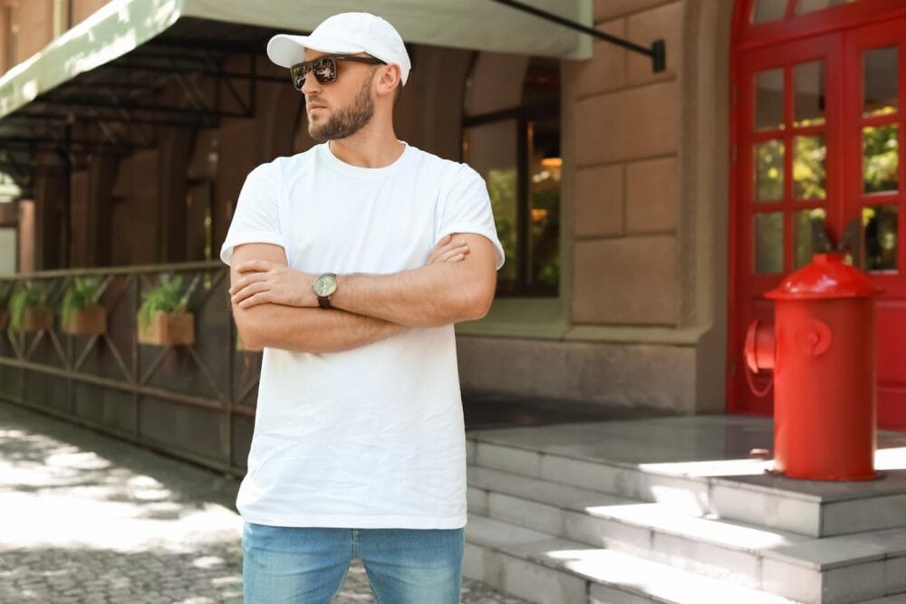 man standing confidently with a matching white t shirt and baseball hat new era cap rubber band coffee mug new era cap