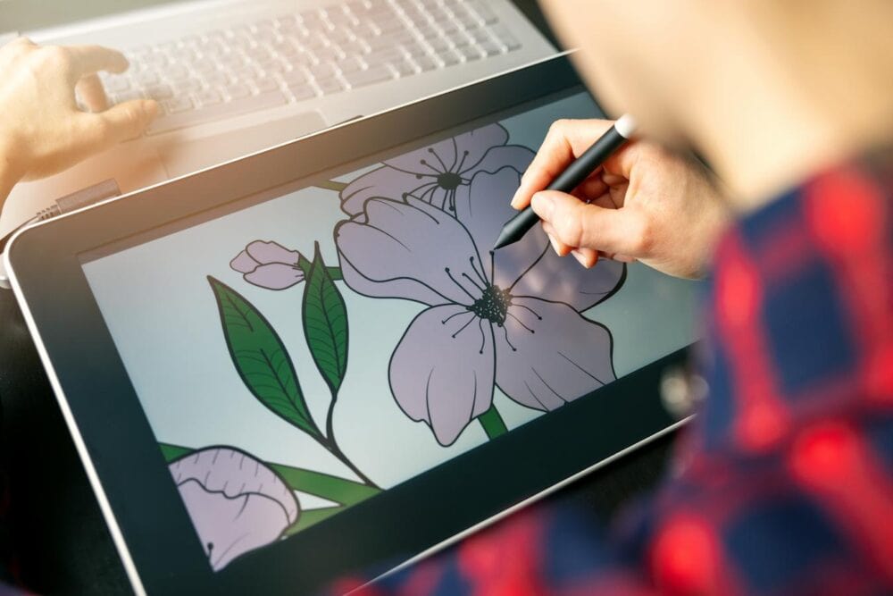 person drawing pink flower on drawing tablet