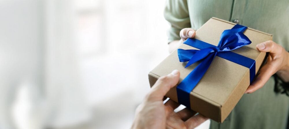 someone being handed a gift box great choice five colors organization new employees water bottles store